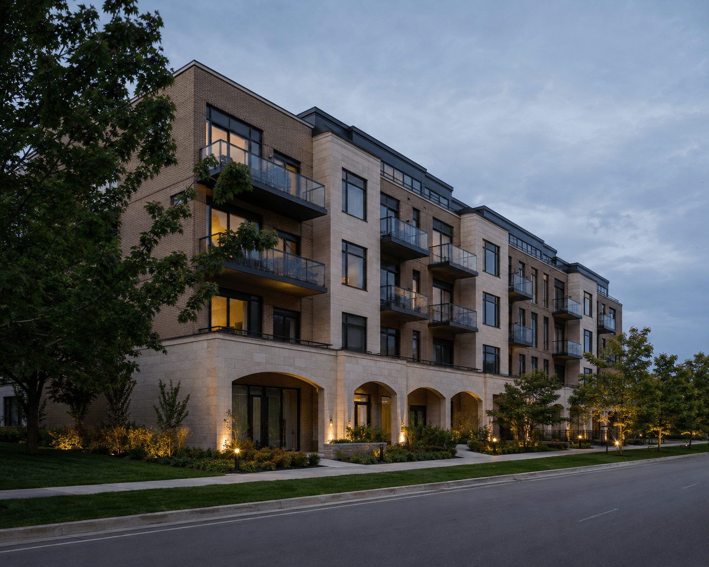 Contemporary residential building with warmly lit windows at dusk